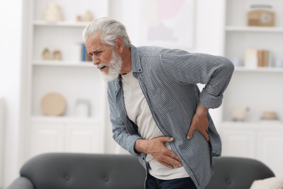 An old man suffers from back pain